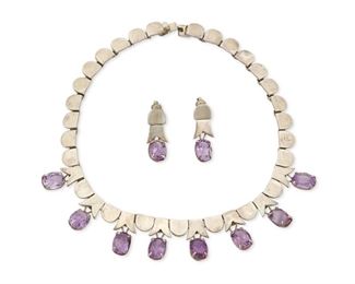 336
A Los Ballesteros Amethyst And Silver Set
1942-1980, Taxco, Mexico
Necklace and one earring stamped with partial stylized B for Los Ballesteros; Further stamped: Taxco / Sterling [on clips]
Comprising a silver geometric link collar necklace with eight suspended claw-set faceted amethysts and matching clip earrings

3 pieces
Necklace: 16" L x 1" H; Earrings: 1.5" L x 0.5" W
116.5 grams gross
Estimate: $500 - $700