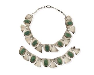350
A Set Of Mexican Silver And Green Stone Jewelry
Second Half 20th Century; Mexico
Stamped with AE within heart-shaped "M;" Further stamped: Sterling / Mexico
Comprising a link necklace with oval green cabochons alternating with stylized panels, along with a matching bracelet, similar to pieces designed by Fred Davis

2 pieces
Necklace: 16" L x 1.125" H; Bracelet: 7.75" L x 1.125" H
146.4 grams gross
Estimate: $500 - $700