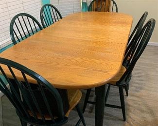 Table with 2 leaves and 6 chairs. 2 are arm chairs.
