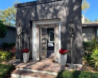 I neither side of the door you can see beautiful potted flowers and Lottie Skinny Female Statues designed by Norman Waite.