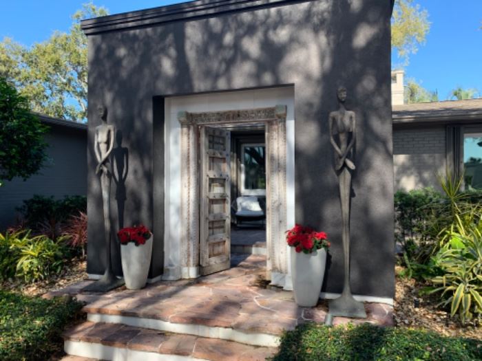 I neither side of the door you can see beautiful potted flowers and Lottie Skinny Female Statues designed by Norman Waite.