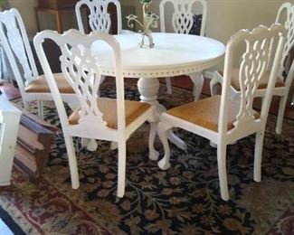 White dining table and chairs and rug