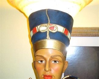The top of head dress is a lamp. She is made from some kind of composite cast material and hand painted.