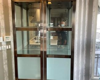 Pair of modern glass and metal cabinets with privacy glass. Interior lighting. Each measures 21" W x 78" H. Photo 2 of 2.
