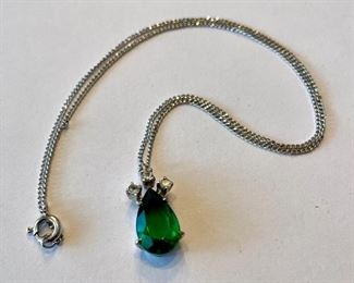 Silver pendant necklace with emerald and diamonds.