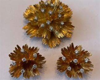 Gold flower pin and earring set with diamond accents.