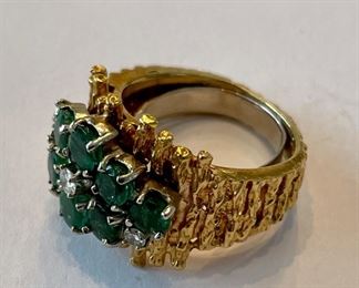 Gold ring with emerald and diamond accents.