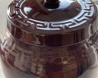 Lidded brown jar with Greek key trim and floral design. Photo 2 of 2.