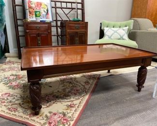 Cocktail table with class top and carved wood legs. Measures 50” x 30” x 18”. Photo 1 of 2.