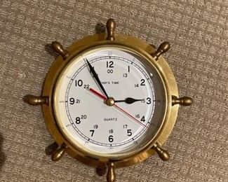 Brass quartz ship's wheel clock. Measures 9.5" D.