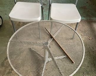 Small patio table and pair of white chairs.