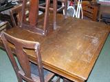 Square oak table with bulbous legs. Four t-back oak chairs. Circa 1900.