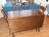 Nice walnut drop lead table. Also a set of four plank seat pressed back chairs.