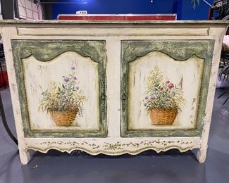 Antique ivory whit washed solid wood credenza with hand painted flower baskets. Two doors open to large storage with two shelves dimensions: 59 “wide x 14 1/2 “ deep x 42 1/2 “ high. Beautiful piece for any room.