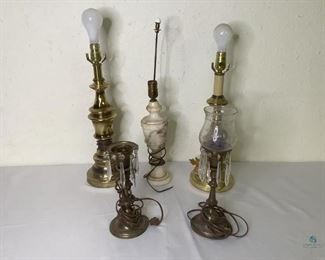 Table Lamps
Five (5) table lamps without shades. One (1) pair of bronze colored metal lamps with hanging glass chandelier pieces. One (1) has a glass shade. Some glass pieces are missing and the metal shows wear. One (1) pair of brass colored metal lamps, not a matching set. One (1) lamp with what appears to be marble, very heavy. It has a carved design. It has very small nicks in the base and has original cord, but no plug. All are of unknown working condition.