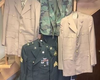 Military Uniforms & Accessories
Two (2) green Army uniforms (jackets & pants, Sizes 43B and 46R). Two (2) light brown Naval uniforms (jackets, shirts, & pants, sizes unknown). One (1) green camo jacket (size unknown) has tears on inside of jacket. Two (2) black Navy uniforms (jacket, pants, necktie, sizes unknown). One (1) Navy black pea coat (size unknown). All uniforms in good condition (appeared to have been cleaned in 60's and stored since). Includes four (4) US Flags (one rolled, two folded in triangles, one new in bag). Box of military regalia (pins, badges, epaulettes, gloves, challenge coins, etc.) Three (3) berets. Front page of Rocky Mountain News, dated December 8, 1941.