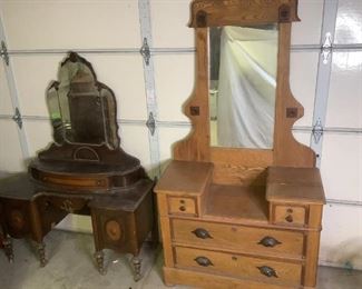 Antique Furniture
Three pieces in this lot. One is a matching pair! One 1933 chest of drawers in dark wood with scroll work on the front. It has four (4) drawers and a top curved covered trinket holder, 53"Hx34"Wx18"D. Matching dressing table with detachable mirror. It has one small center drawer and side cabinets, 77"Hx42Wx18D (with mirror). Both have many scratches, scuffs and areas of missing/peeling wood. Also, a light wood dresser with detachable mirror. It has four (4) drawers, 64"Hx46"Wx18"D. It is missing two (2) wheels, one from each side, the wood around the mirror has been reinforced on the back. It has multiple scratches, scuffs and a large crack in the wood on the top right side of the dresser.