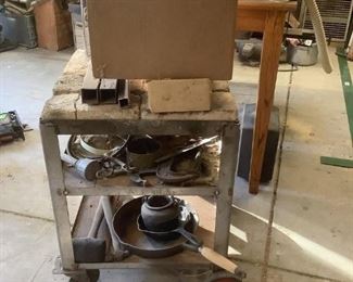 Metal Work Cart w/Heat Resistant Bricks
Homemade metal work cart with heat resistant bricks on top. Includes box of miscellaneous metal bits, parts, C-clamps, cast iron pan, mallets, & more.