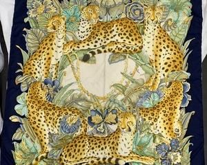 A beautiful 34" square silk scarf by designer Salvatore Ferragamo, featuring six leopards amidst exotic botanicals, with a navy border. Made in Italy, 100% silk. The luxurious scarf is in excellent condition