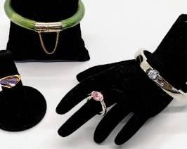 This mixed jewelry lot of two rings and two bracelets has colors and styles for every mood:

Jadeite bangle with gold-tone chain and Asian script decor and button-opening clasp, 2.5" wide on the inside
White crystal silvertone solid metal bracelet with pull-open clasp, 2.5" wide inside oval
Gold-tone size 7-1/4 amethyst ring with sharp-angled, jutting stone
Pink crystal silver-tone size 7 ring with sparkling shoulder facets