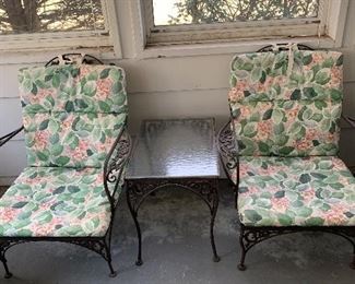 Pair of wrought iron chairs with cushions.  Matching end table with glass top.