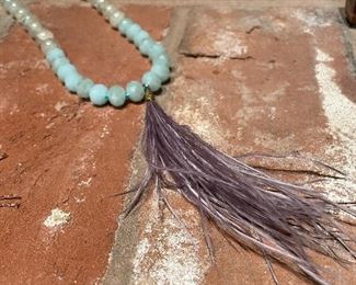 $42; necklace of natural stone and ostrich feather with blue knotting