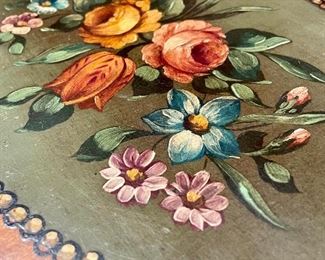 close up of hand painting on the largest of the nesting tables