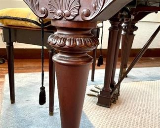 close up of exquisite carved legs on grand piano