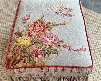 $350; custom upholstered wing back chair and ottoman with red floral and red trim; ottoman has custom needlepoint dove and floral scene and skirt; ottoman and needlepoint is in excellent condition; chair has some wear; chair 33”w x 31”d x 39”h; ottoman 23”w x 18”d x 13”h