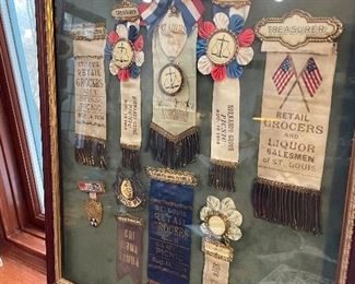 $200; framed collection of 10 vintage “Retail Grocers” medallions and ribbons; 18”w x 21”h
