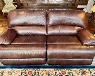 $650; Mechanized reclining, pebbled leather couch; leather has some scratches; 80”w x 35”d x 38”h