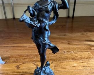 Bronze statue of a lady holding a basket with flowers