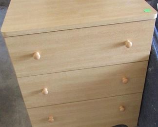 Small three drawer blond colored chest of drawers.
