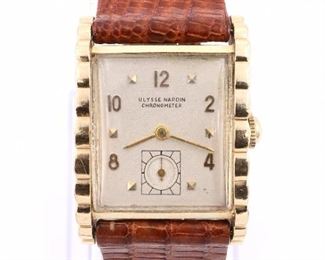 Ulysse Nardin 14k Gold gentleman's wristwatch.  1950's vintage with a 17 j, manual wind movement #544890, Silvered dial, Arabic numerals and subsidiary seconds dial.   23 x 33 mm 14k Yellow Gold case with scalloped sides and a replaced Brown leather band with 18k buckle.  26.0 grams total.  Light case wear, winds, sets and running when cataloged, case back engraved "To Marvin C. Berry, from Your Friends, 8.21.50" .  ESTIMATE $2,000-3,000