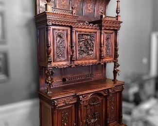 1800s walnut cabinet with hand-carved details- mythical creatures, including Pan, with crystal eyes. 