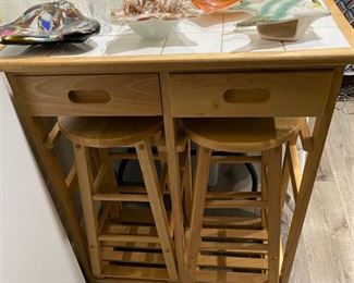LIKE NEW ROLL AROUND DROP LEAF TILE ISLAND/CART WITH 2 STOOLS NEATLY FITTED UNDERNEATH AND 2 DRAWERS.