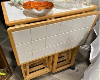 LIKE NEW ROLL AROUND DROP LEAF TILE ISLAND/CART WITH 2 STOOLS NEATLY FITTED UNDERNEATH AND 2 DRAWERS.
