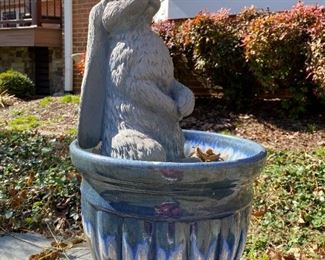 Planter with rabbit garden ornament.