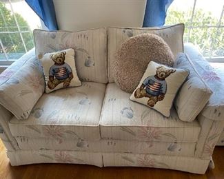 Love seat with small pillows.
