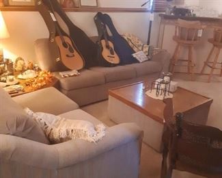 The furniture in the basement family room is a 4-piece set by Bassett. The set includes corner table, and storage coffee table. The sofa features a pull-out bed. The loveseat features a recliner on the end.