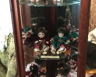Marie Osmond dolls inside cabinet with curved front
