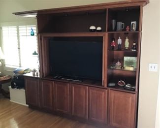 Entertainment center. 7 foot tall; 8 foot wide, 2 feet deep. Built-in lighting with glass and wood shelves. 6 doors. Excellent condition. Displayed items sold separately. Must be removed by purchaser within 72 of sale end.