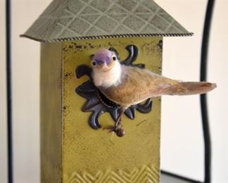 googly-eyed bird on metal birdhouse