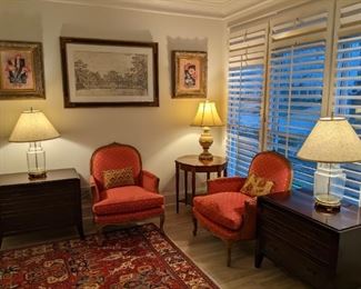 Relaxing sitting area in the master bedroom, with pair of French Bergere chairs, with down cushions, pair of mahogany 3-drawer end tables and nicely framed original artwork.