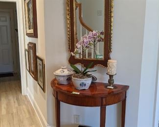 Nice reproduction mahogany/gilt wood wall mirror, w/eagle topper and cascading bluebells, delightfully paired with inlaid mahogany demilune side table, pair of Asian blue/white lidded porcelain pots, one with a fresh orchid plant.