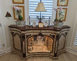 Vintage Henredon lighted sideboard, with two side doors and center silverware drawer, set of four nicely framed botanicals, from Pineapple House (overpriced "design" store in the 1980's), live orchids in Asian porcelain cachepot, English Sheffield candlesticks, assorted silverplated goblets, gravy boat, hotel silver pitcher, large cut crystal ice bucket and crystal shell-shaped server.