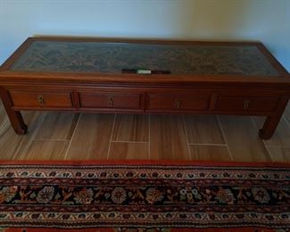 Close-up of the Asian wooden coffee table, with hand-carved top detail.