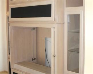 Large entertainment center with glass door display shelves.