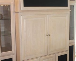 Large entertainment center with glass door display shelves.