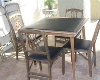 Leatherette folding games table and four folding chairs.